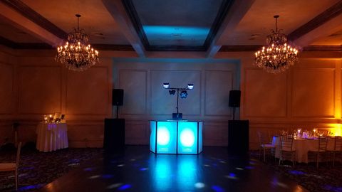 Grand ballroom with chandeliers and uplighting, set for a wedding
