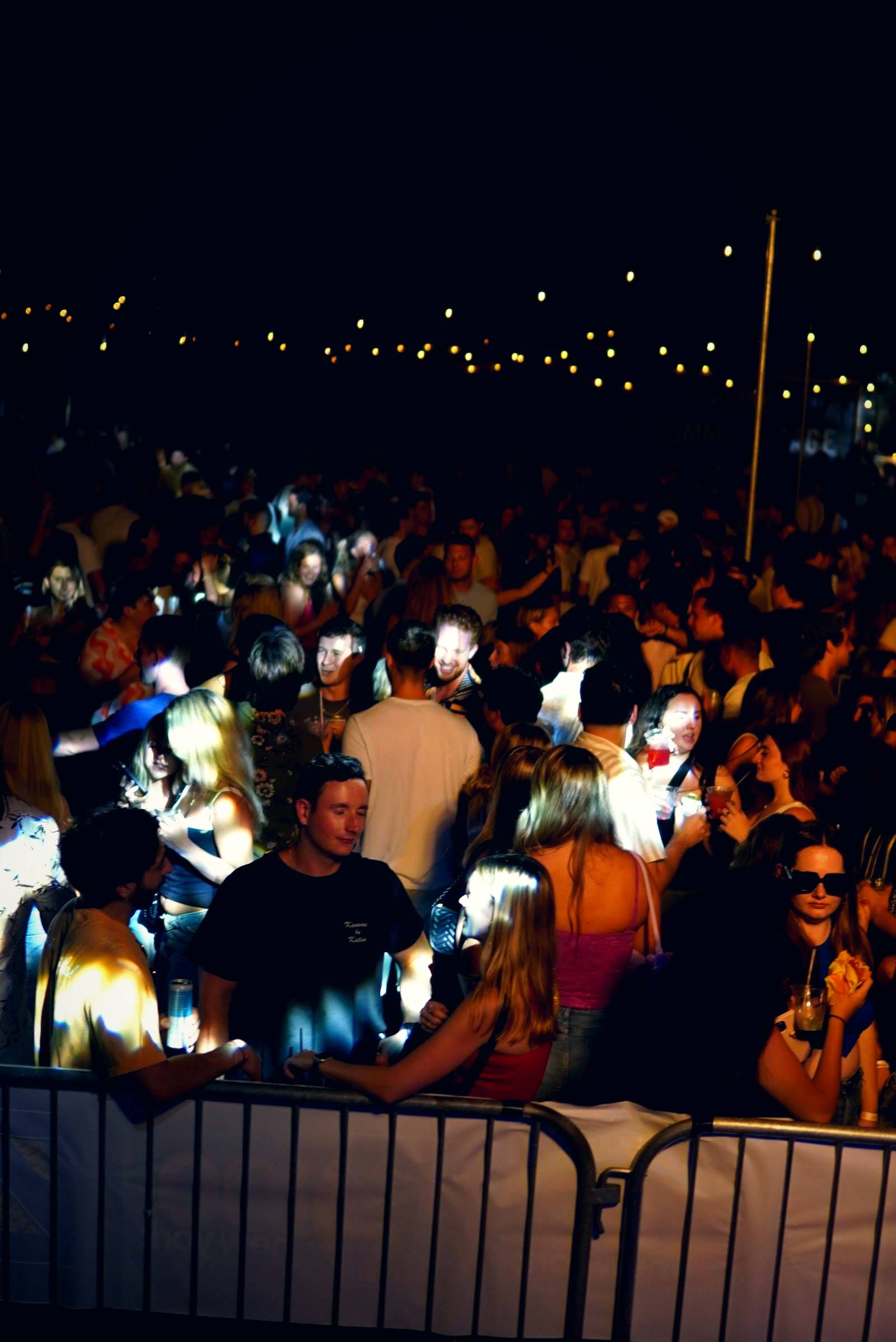 Large celebration crowd under warm string lights